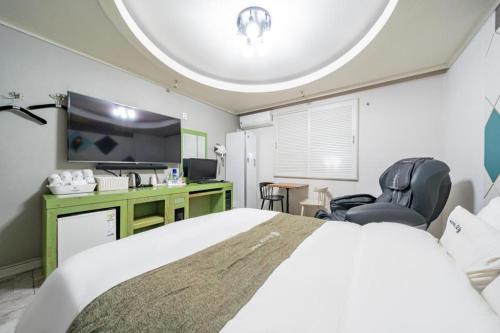 a bedroom with a bed and a desk and a tv at Luxury Motel Daejeon in Daejeon
