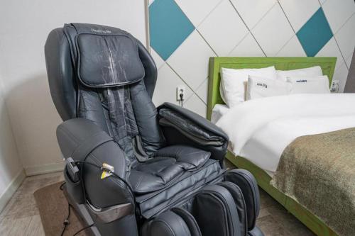 a black office chair in a bedroom with a bed at Luxury Motel Daejeon in Daejeon