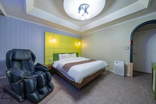 a bedroom with a bed and a chair in it at Luxury Motel Daejeon in Daejeon