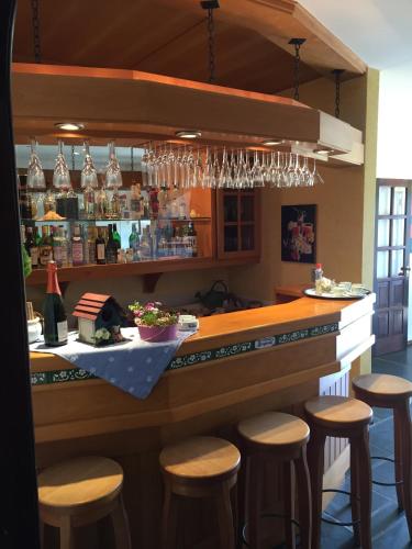 a bar with wooden stools and wine glasses at Hotel Bergblick in Pomerode