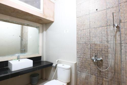 a bathroom with a shower with a toilet and a sink at Sanur Ayu Hotel in Sanur