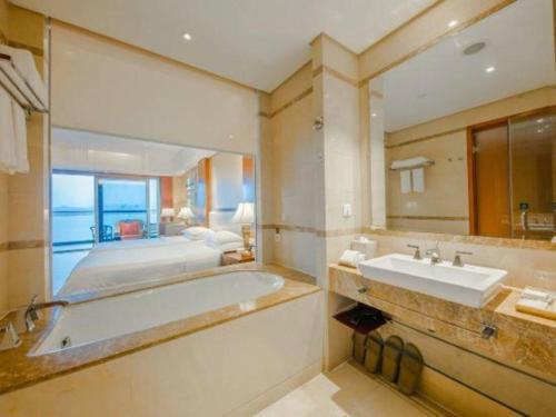 La salle de bains est pourvue d'une baignoire, d'un lit et d'un lavabo. dans l'établissement Hangzhou 1000Island Lake Greentown Resort Hotel, à Lac Qiandao
