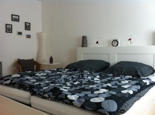 a bedroom with a bed with a black and white comforter at Ferienwohnung J.Weber in Hornbach