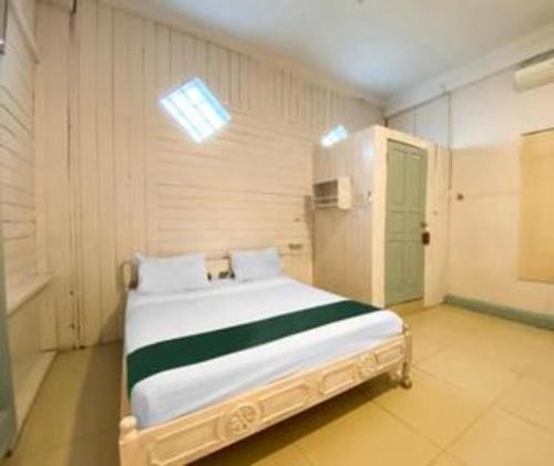 a bedroom with a large white bed in a room at Bunda House Syariah in Padang