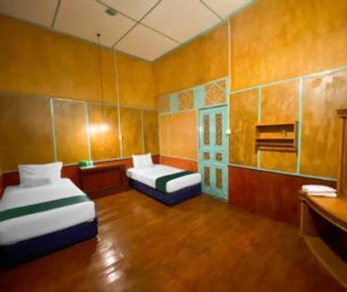 a small room with two beds in a room at Bunda House Syariah in Padang