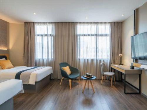 a hotel room with a bed and a desk at Home Inn Selected Xiamen University Zhongshan Road in Xiamen