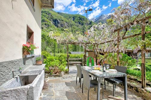 a table and chairs on a patio with a mountain at Casa Kaia Verzasca - Happy Rentals in Gerra Verzasca