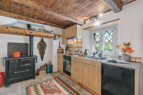 a kitchen with a black stove and a sink at Casa Kaia Verzasca - Happy Rentals in Gerra Verzasca