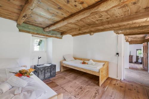a bedroom with two beds and a wooden ceiling at Casa Kaia Verzasca - Happy Rentals in Gerra Verzasca