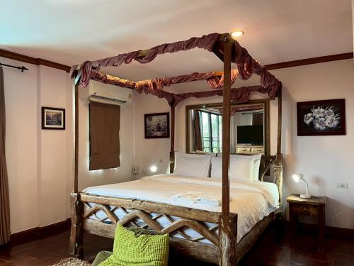 a bedroom with a canopy bed and a television at Thara Bayview Villa, SHA Certified in Ao Nang Beach