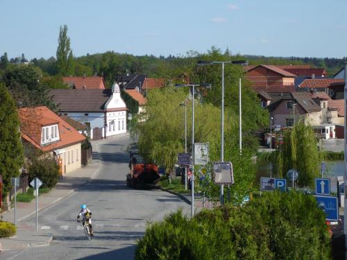 a person riding a bike down a street in a town at Rivendell Apartments in Prague
