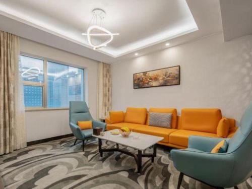 a living room with an orange couch and two blue chairs at Shaanxi Business Hotel in Shanghai