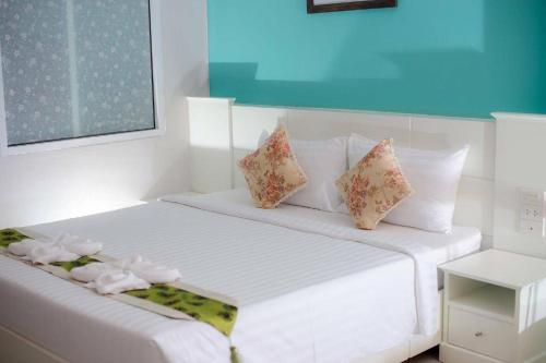 a white bed with flowers on it in a room at Waenpetch place Hotel in Ubon Ratchathani