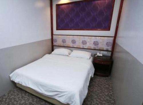 a bedroom with two beds and a painting on the wall at Hotel 165 in Singapore