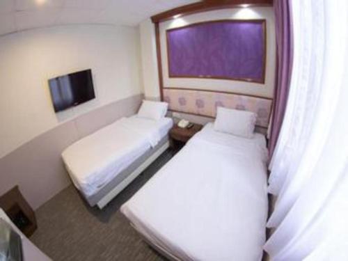 a hotel room with two beds and a window at Hotel 165 in Singapore
