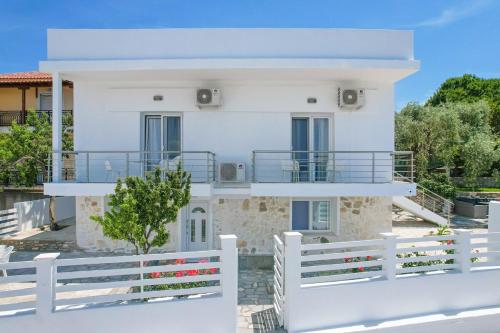 a white house with a fence in front of it at Chrissi Seastar in Skala Sotiros