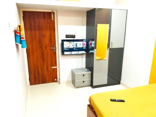 a room with a mirror and a door and a television at ASSHAPPYSTAYINN HOTEL in Tiruchchirāppalli