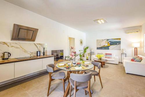 a kitchen and a living room with a table and chairs at Villa Arenella by Villa Plus in Arenella