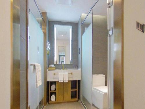 a bathroom with a sink and a toilet and a mirror at James Joyce Coffetel Beijing Yizhuang Rongjing East Street Subway Station in Beijing