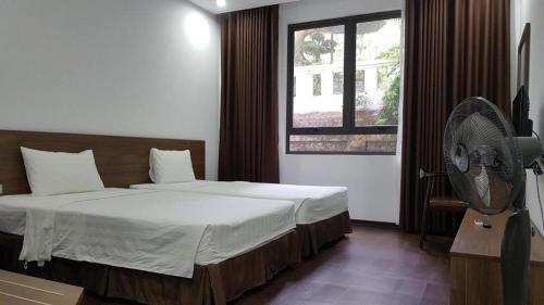 a bedroom with a bed with a fan and a window at LAKESIDE DAILAI HOTEL in Ngọc Quang
