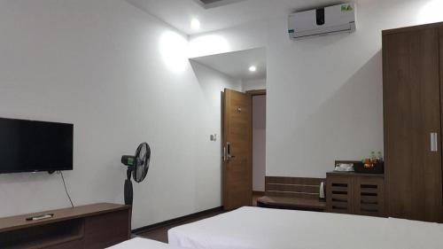 a bedroom with a bed and a flat screen tv at LAKESIDE DAILAI HOTEL in Ngọc Quang