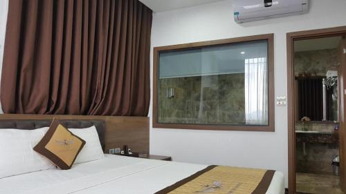 a bedroom with a bed and a large window at LAKESIDE DAILAI HOTEL in Ngọc Quang