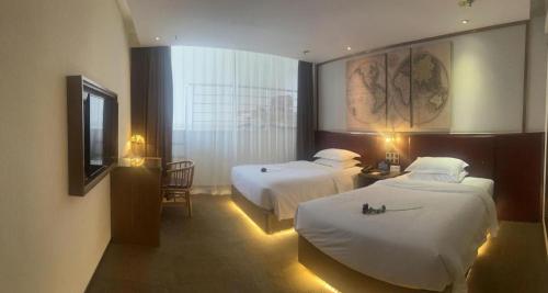 a hotel room with two beds and a television at James Joyce Coffetel Beijing Yizhuang Rongjing East Street Subway Station in Beijing
