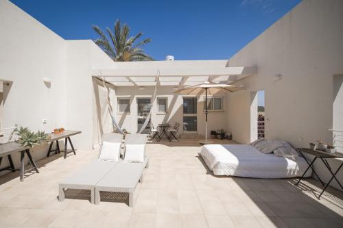 a bedroom with a bed and a patio at שדות וים in Shave Ẕiyyon