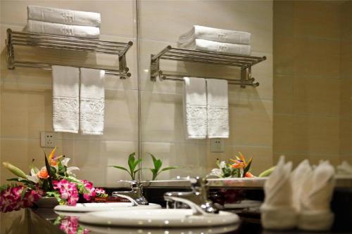 La salle de bains est pourvue d'un lavabo, de serviettes et d'un miroir. dans l'établissement Ramada Encore, à Kanggar