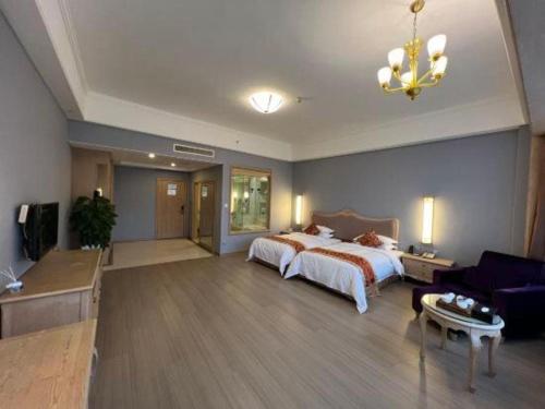 a large bedroom with a bed and a living room at Putian Haiyuan International Hotel in Putian