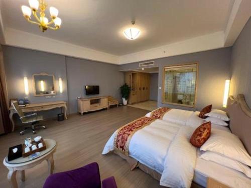 a large bedroom with a large bed and a desk at Putian Haiyuan International Hotel in Putian