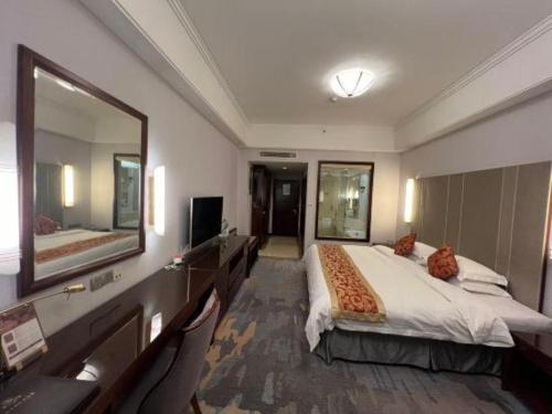 a bedroom with a large bed and a large mirror at Putian Haiyuan International Hotel in Putian