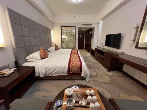 a hotel room with a bed and a television at Putian Haiyuan International Hotel in Putian