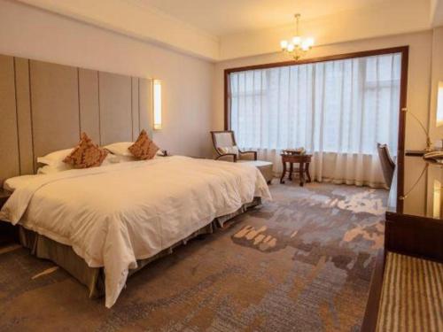 a hotel room with a large bed and a window at Putian Haiyuan International Hotel in Putian