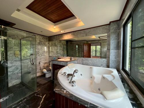 a large bathroom with a tub and a shower at Thara Bayview Villa, SHA Certified in Ao Nang Beach