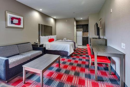 a hotel room with a bed and a couch at Americas Best Value Inn and Suites IAH Airport North in Houston