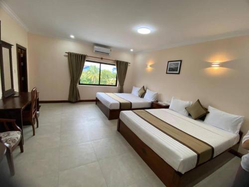 Ένα ή περισσότερα κρεβάτια σε δωμάτιο στο Asian Koh Kong Hotel
