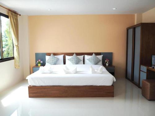 a bedroom with a large bed with white sheets and pillows at Regent Room Hotel in Suratthani
