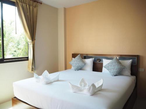 a bedroom with two white beds with a window at Regent Room Hotel in Suratthani