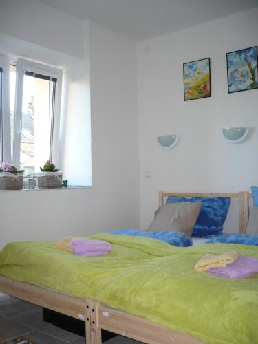 a bedroom with a large bed with green sheets at Rivendell Apartments in Prague