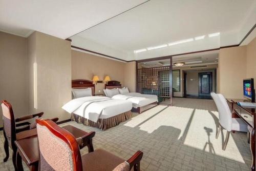 a hotel room with two beds and a television at Telecom International Hotel in Kunming