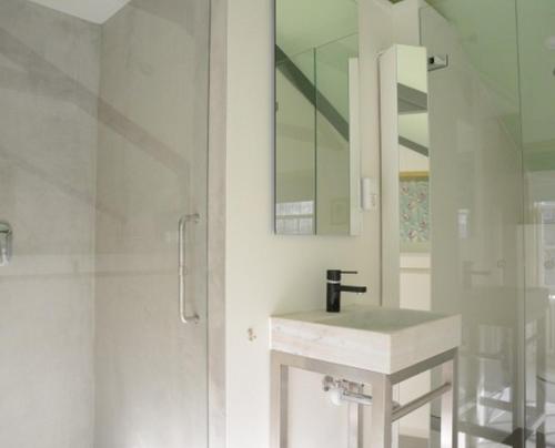 a white bathroom with a sink and a shower at Heer&Meester Bed&Breakfast in Dordrecht