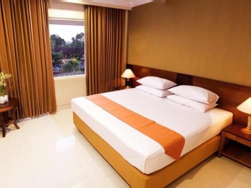 a bedroom with a large bed and a window at Wonua Monapa Hotel Resort in Kendari