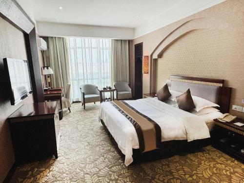 a large hotel room with a bed and a desk at Nile Villa International Hotel in Dongguan