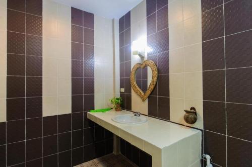 a bathroom with a sink and a mirror at Suvimon Resort in Si Maha Phot