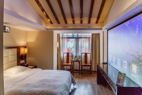 a bedroom with a large screen in a room at Oriental Hotel in Dongguan