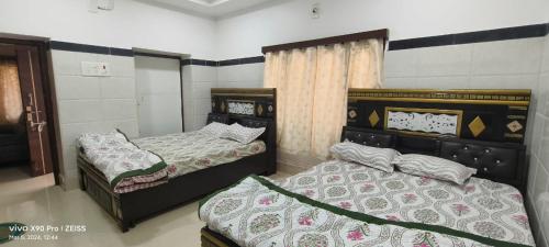 a bedroom with two beds and a window at Sukumar Villas in Nellore