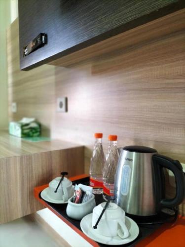 a kitchen counter with a coffee maker and two bottles at GARDEN HOTEL MAJALENGKA in Majalengka