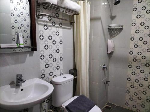 a bathroom with a toilet and a sink at GARDEN HOTEL MAJALENGKA in Majalengka