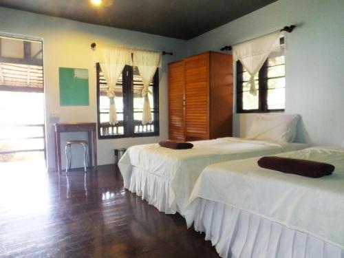 1 Schlafzimmer mit 2 Betten und Holzboden in der Unterkunft Sukorn Cabana Resort in Ko Sukon